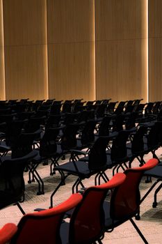 Spacious conference room with rows of black and red chairs.