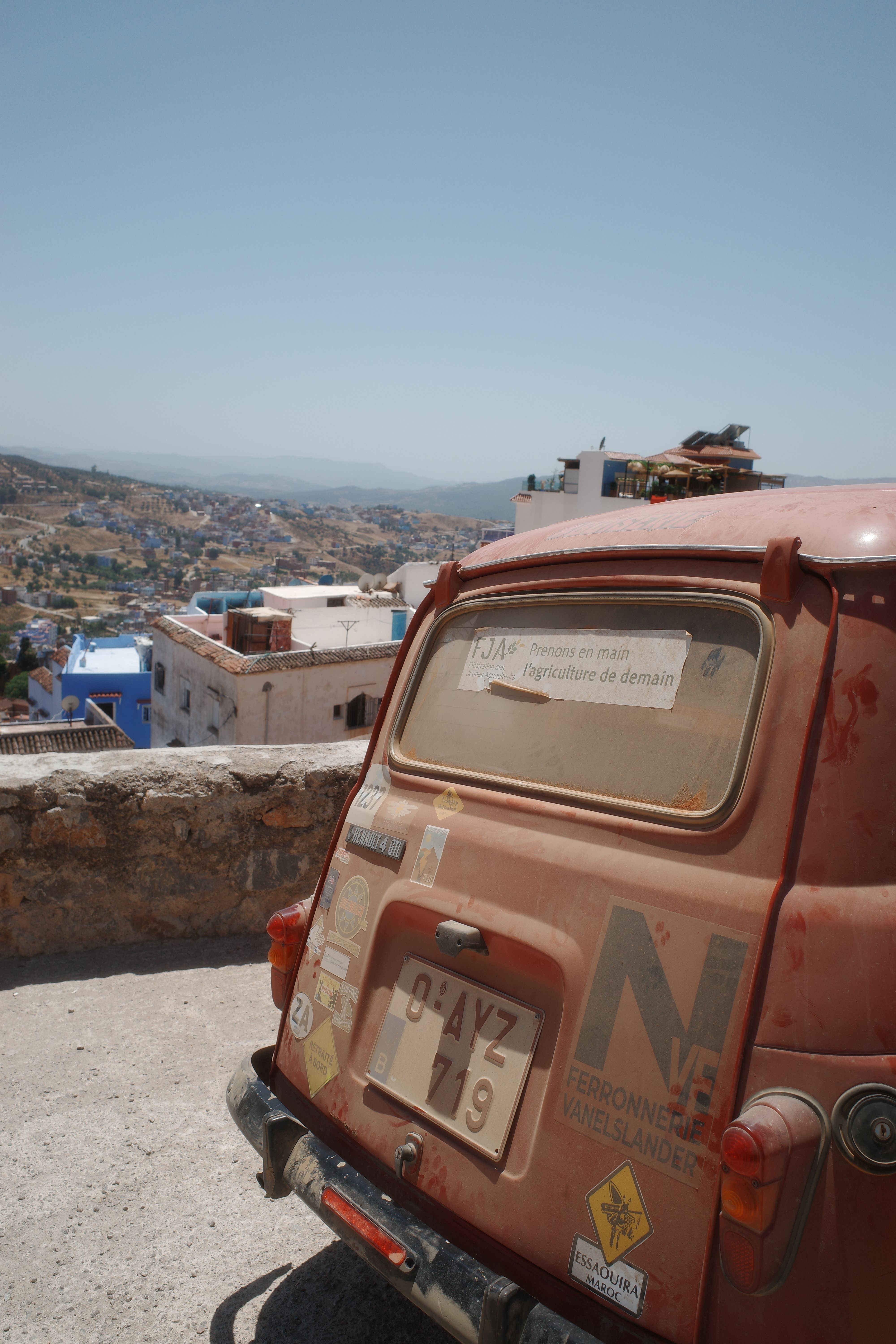 A classic car overlooking the scenic town of Chefchaouen, Morocco on a sunny day.