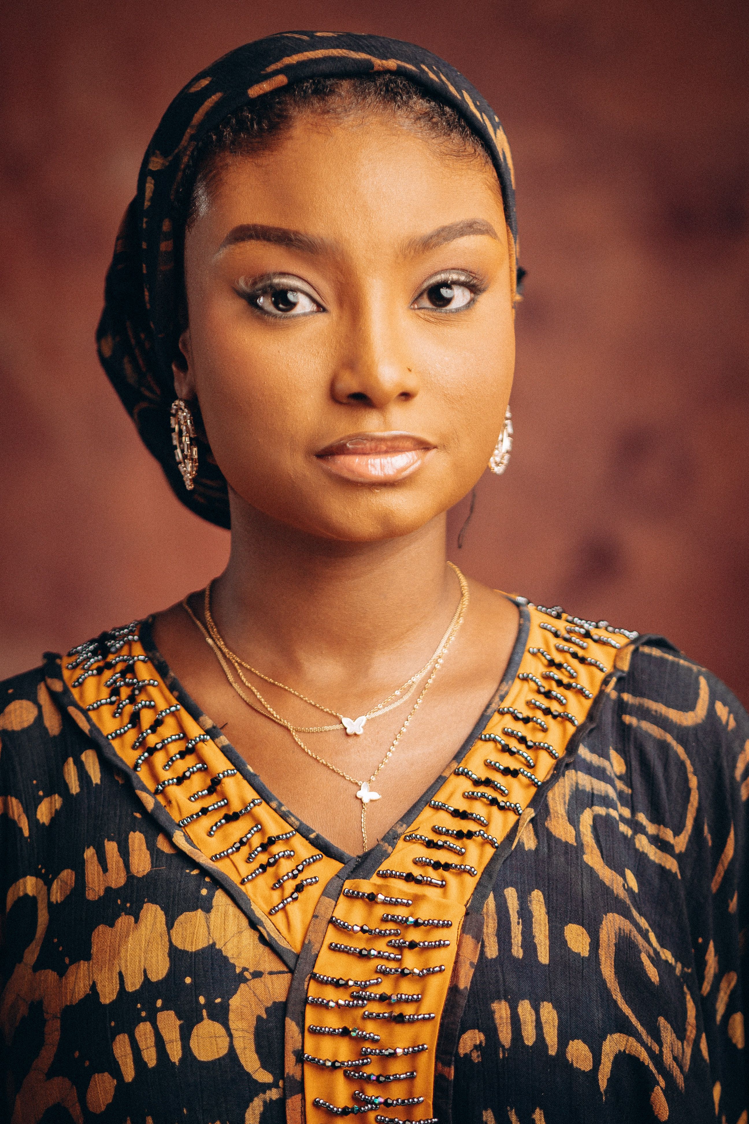Elegant portrait of a woman wearing traditional attire with a warm background.