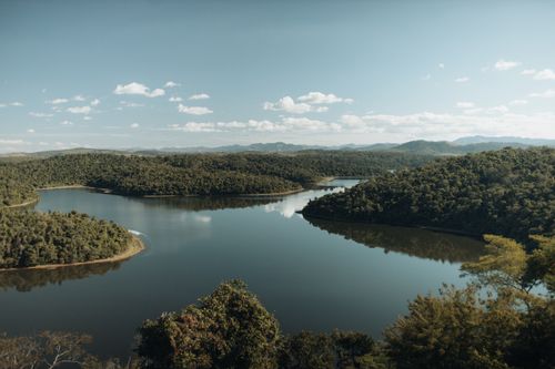 Free A picturesque view of a serene river winding through lush forests in Minas Gerais, Brazil. Stock Photo