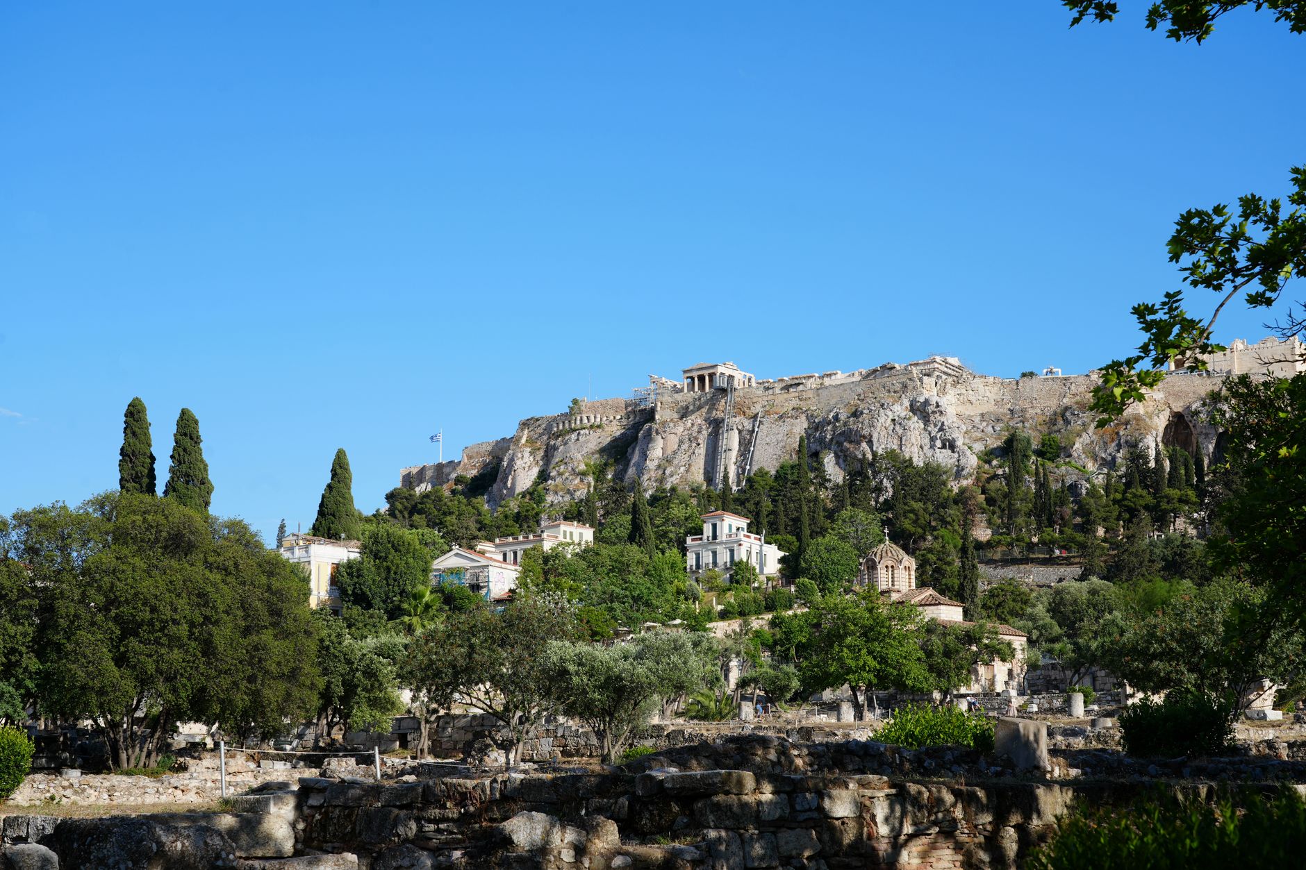 A stunning view of the historic Acropolis in Athens, Greece, under a clear blue sky.