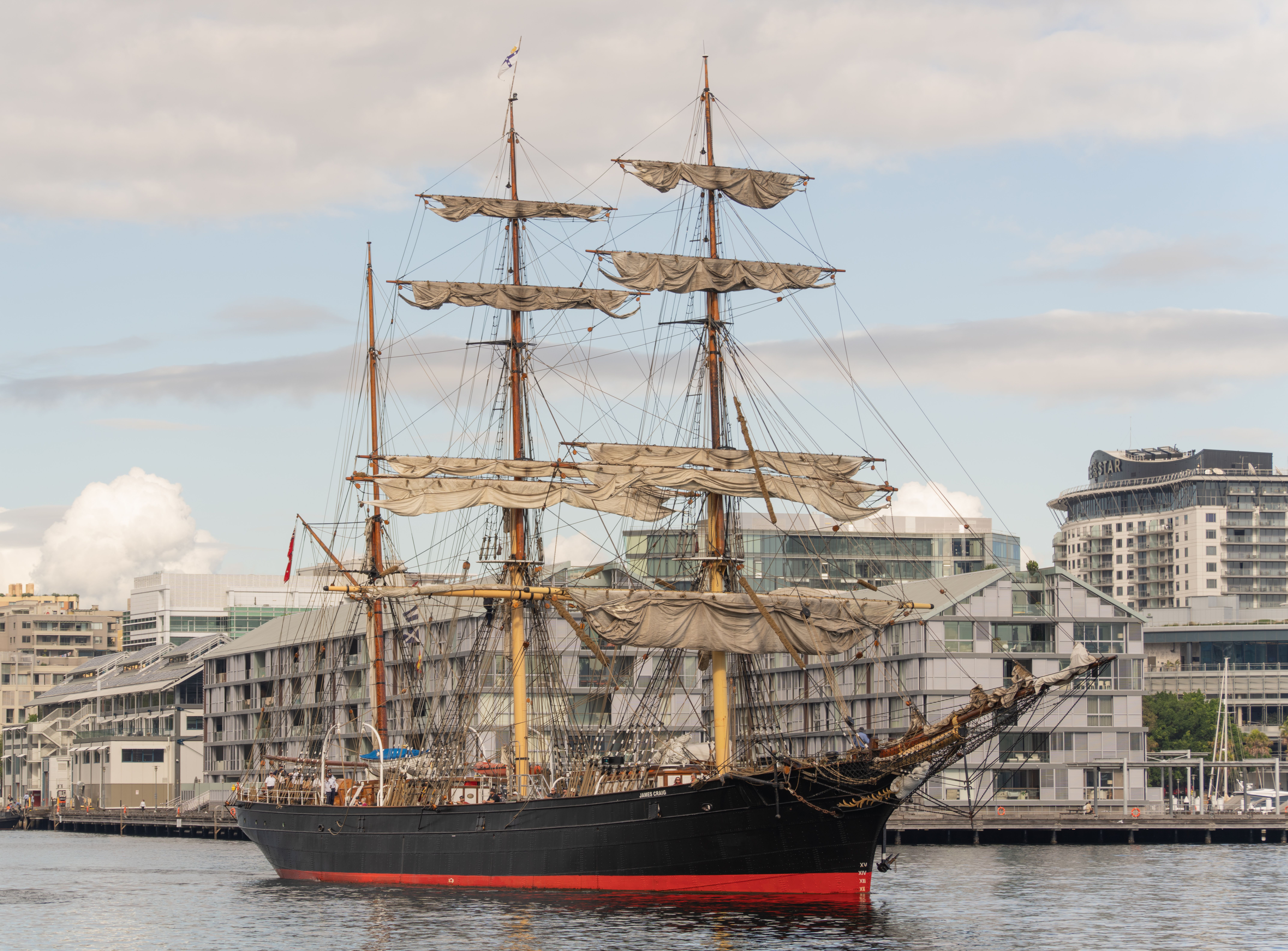 A majestic tall ship anchored at Barangaroo, Sydney with cityscape backdrop.