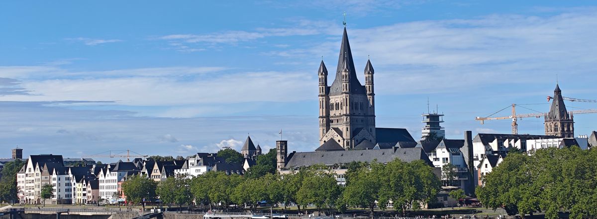 Beautiful Cologne riverside with Great St. Martin Church and ship on the Rhine River.