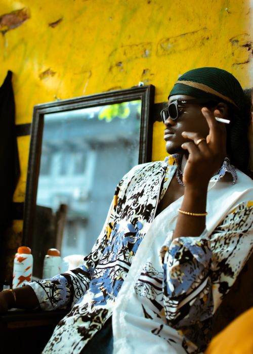 Free A fashionable adult smokes in a vibrant indoor setting, exuding a relaxed and cool vibe. Stock Photo