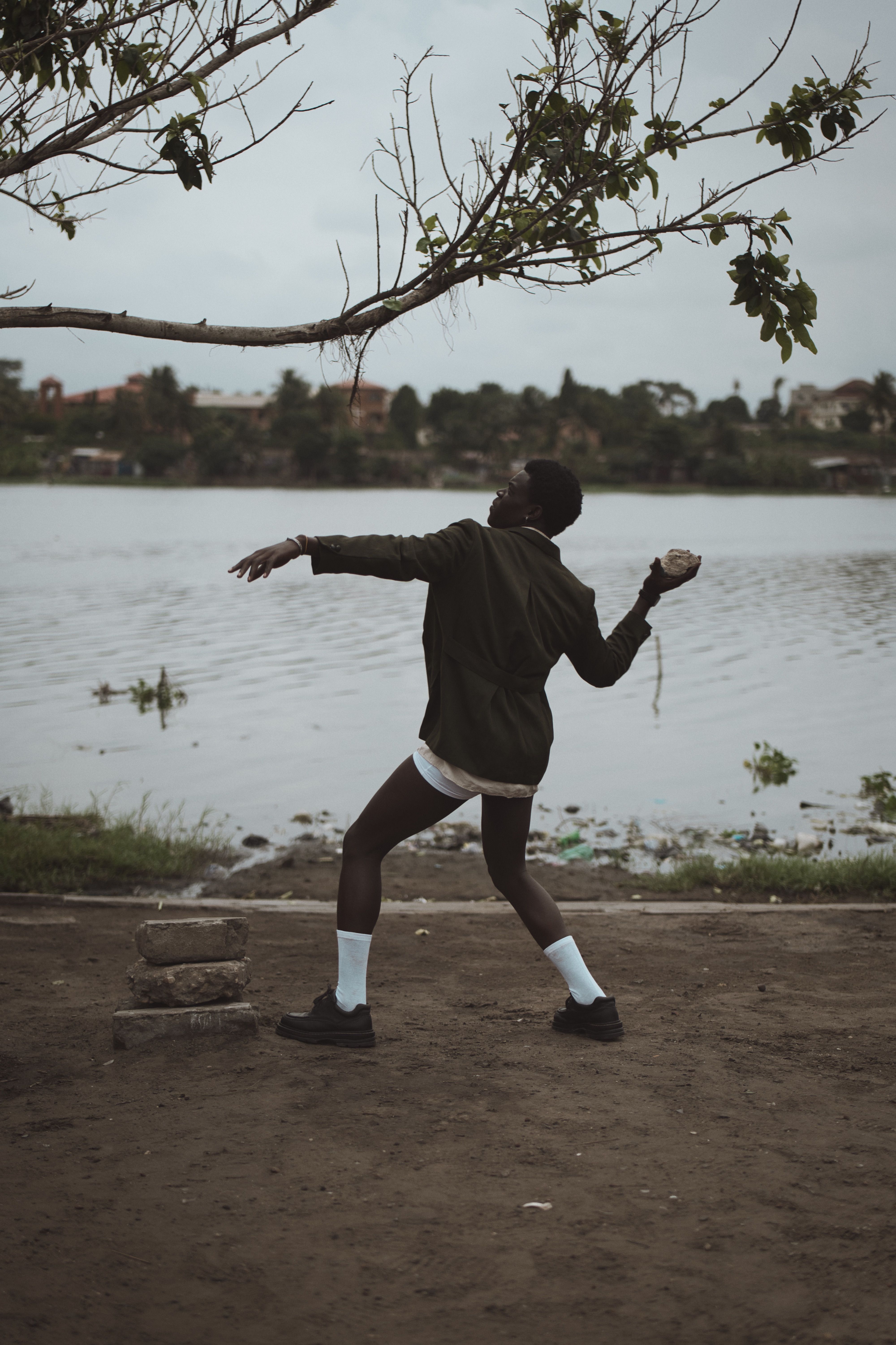 Man Skipping Rocks by Tranquil Riverside · Free Stock Photo