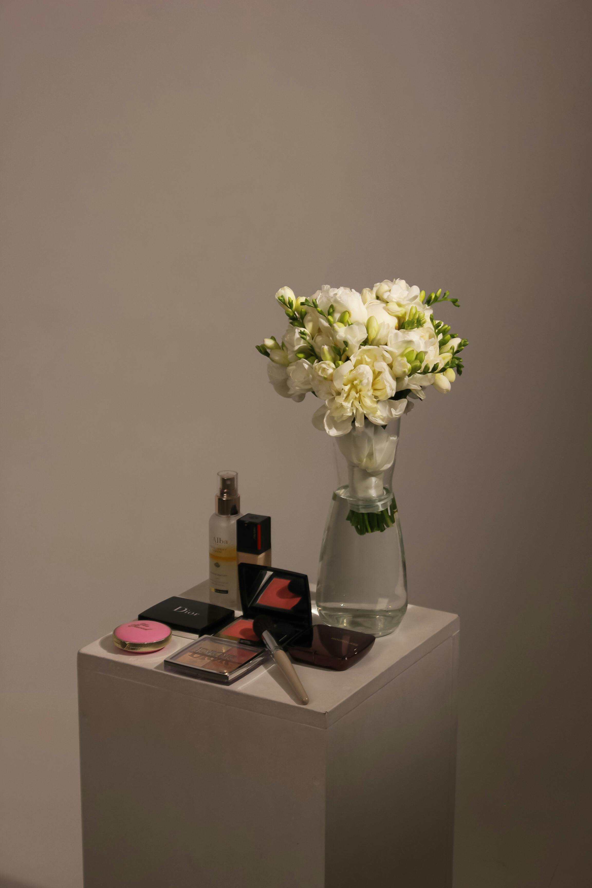 [ColoSach]-aesthetic-display-of-white-flowers-and-cosmetics-arranged-on-a-pedestal,-creating-a-classy-ambiance.