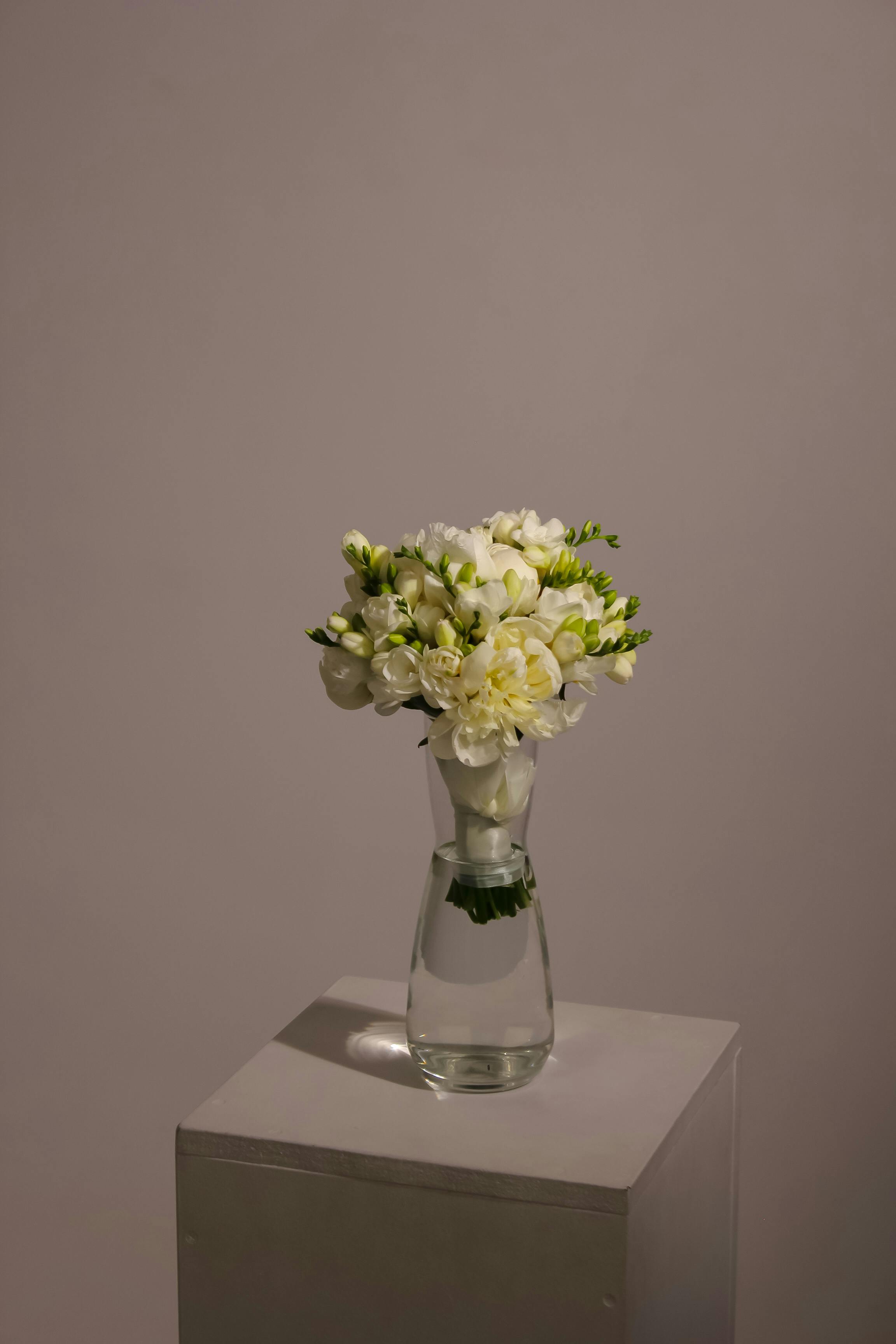 [ColoSach]-simple-yet-elegant-bouquet-of-white-flowers-in-a-glass-vase-on-a-pedestal.