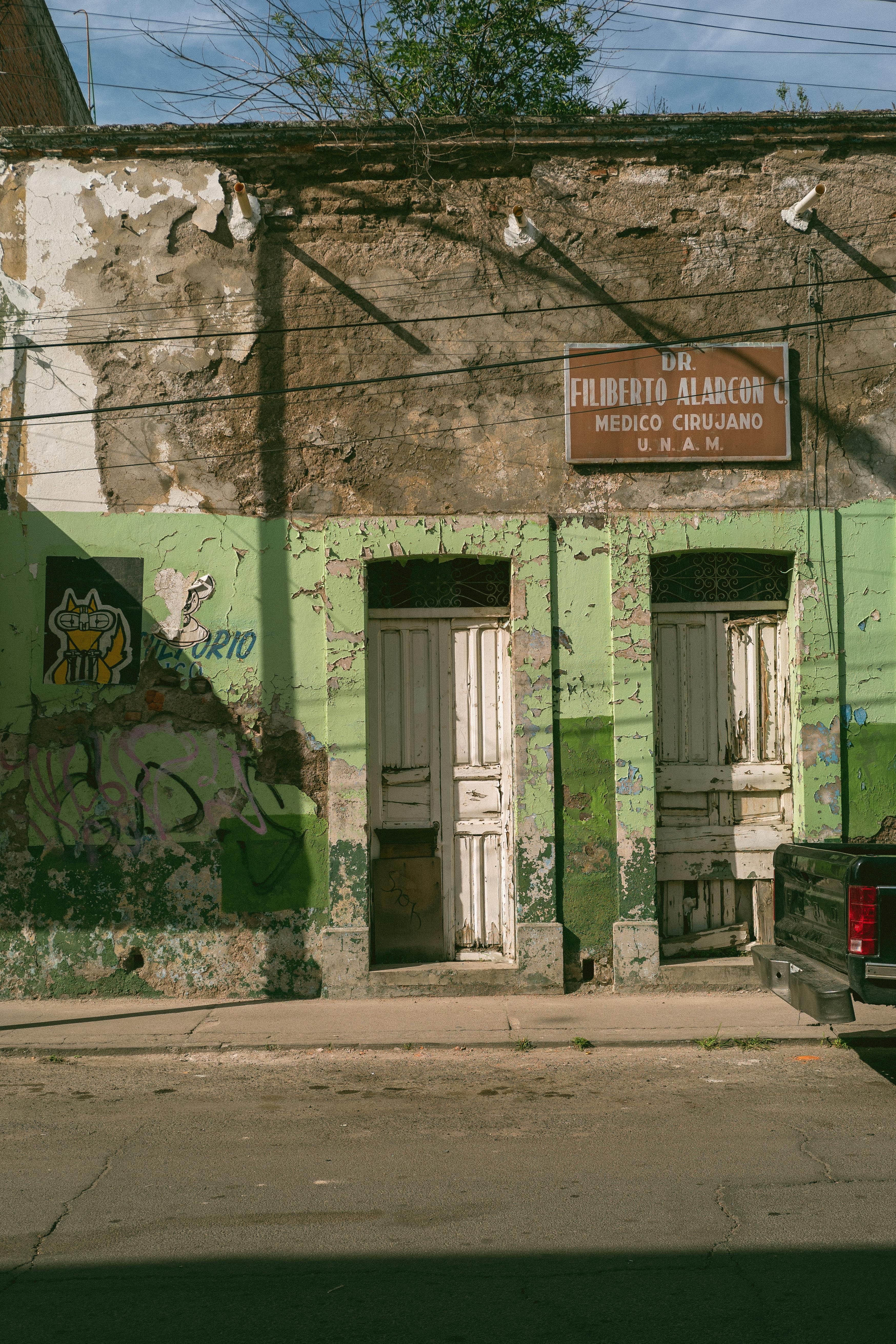 Aged building with peeling paint and vintage signage, capturing urban decay.