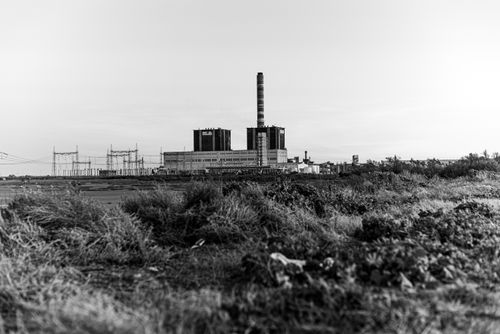 Free Black and white photo of an industrial power plant amidst a barren landscape. Captivating and raw. Stock Photo