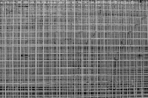 Free A detailed black and white photograph of a geometric wire grid pattern creating urban texture. Stock Photo