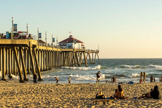 Relaxing summer day at Huntington Beach Pier with people enjoying the sun and surf.