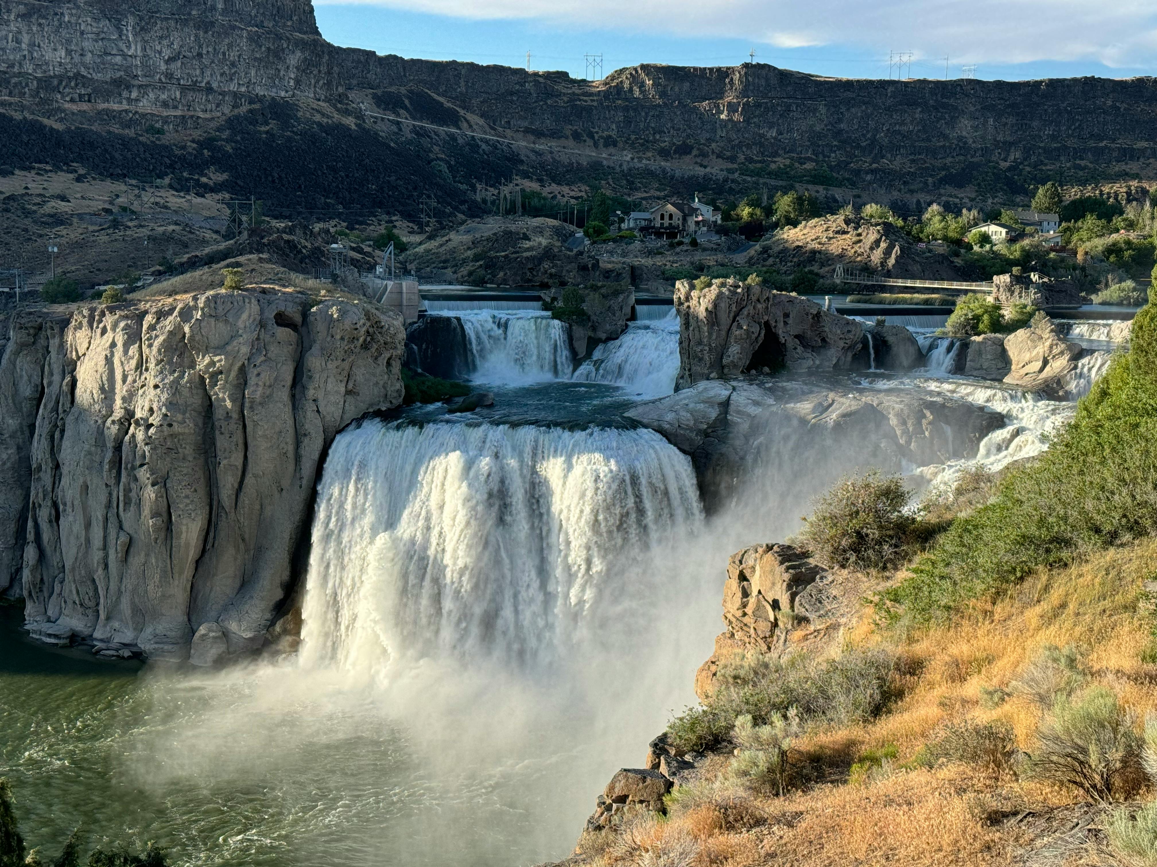 Spectacular Shoshone Falls cascading over rocky cliffs in Idaho with surrounding natural landscape.