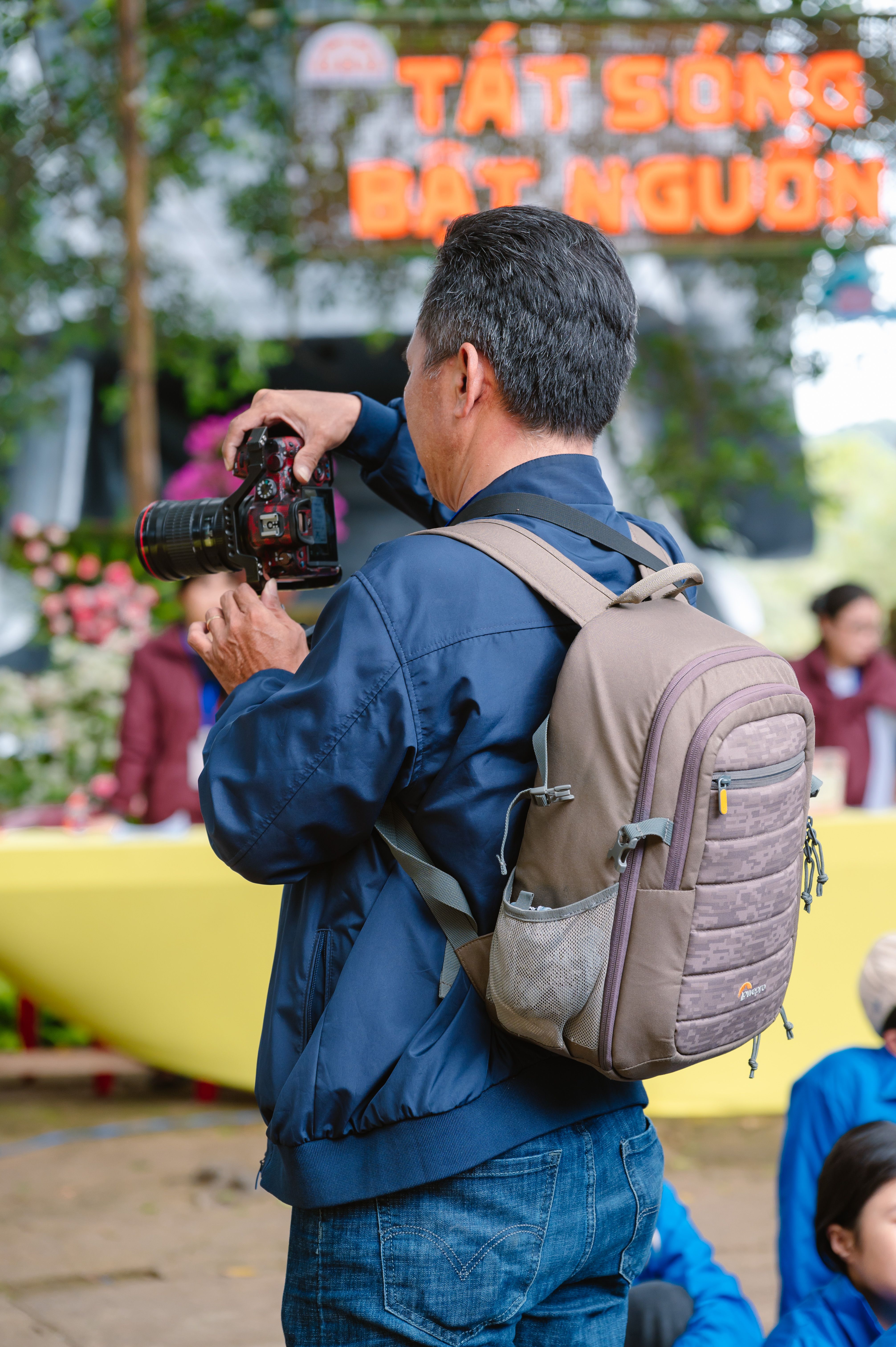 A photographer taking pictures at an outdoor event with colorful decorations.