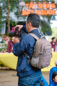 A photographer taking pictures at an outdoor event with colorful decorations.