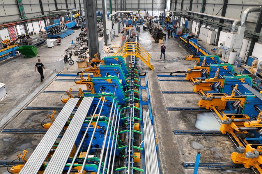 Aerial view of a large manufacturing plant interior with machinery and workers.