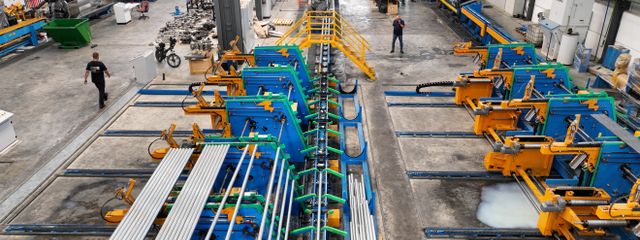 Aerial view of a large manufacturing plant interior with machinery and workers.