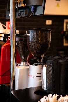 Espresso grinder in a cozy coffee shop interior with soft lighting and warm ambiance.