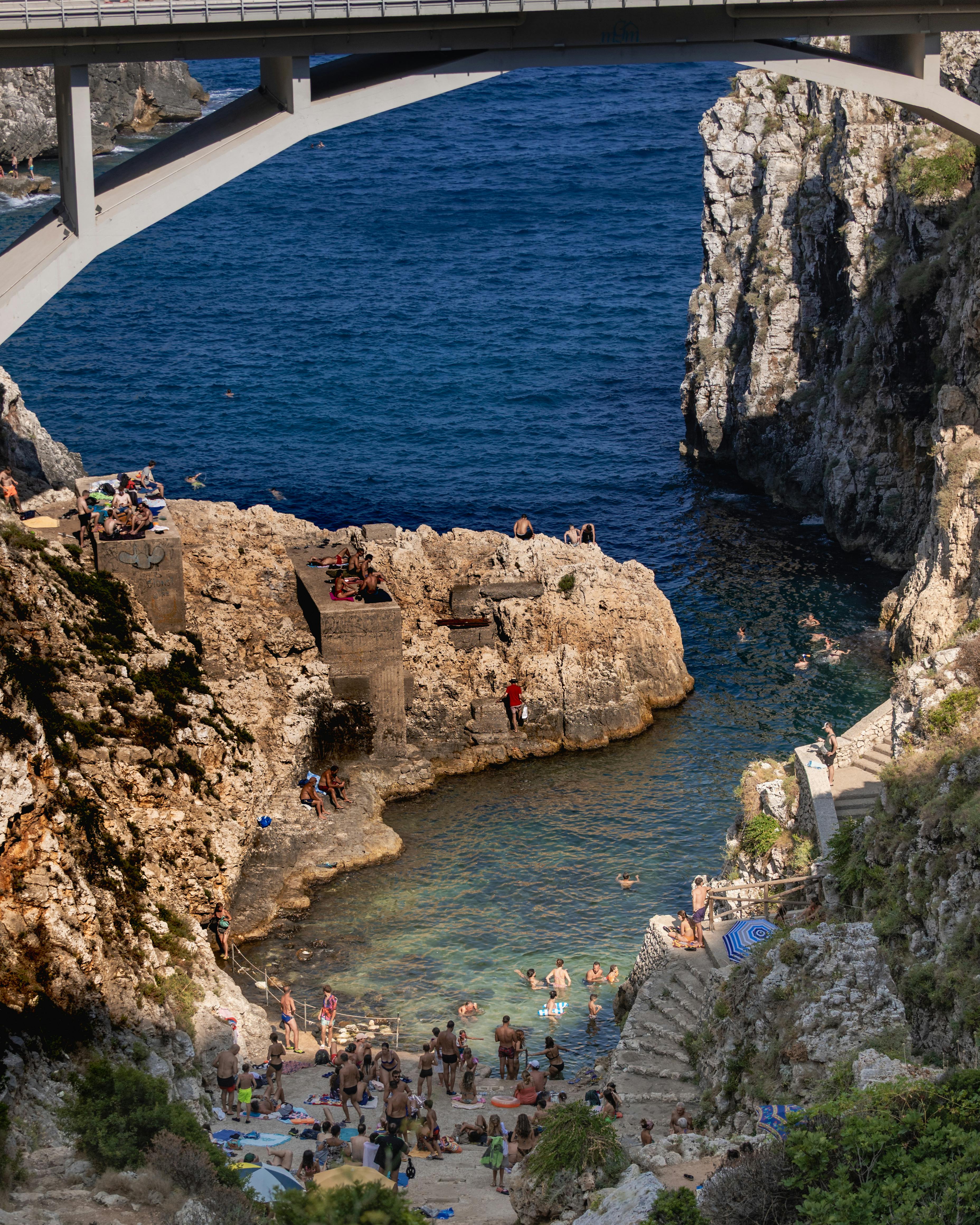 Aerial photograph of a sandy beach meeting the dark blue sea.