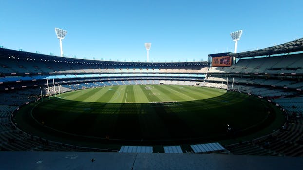 A wide-angle view of the Melbourne Cricket Ground, showcasing its expansive field and seating.