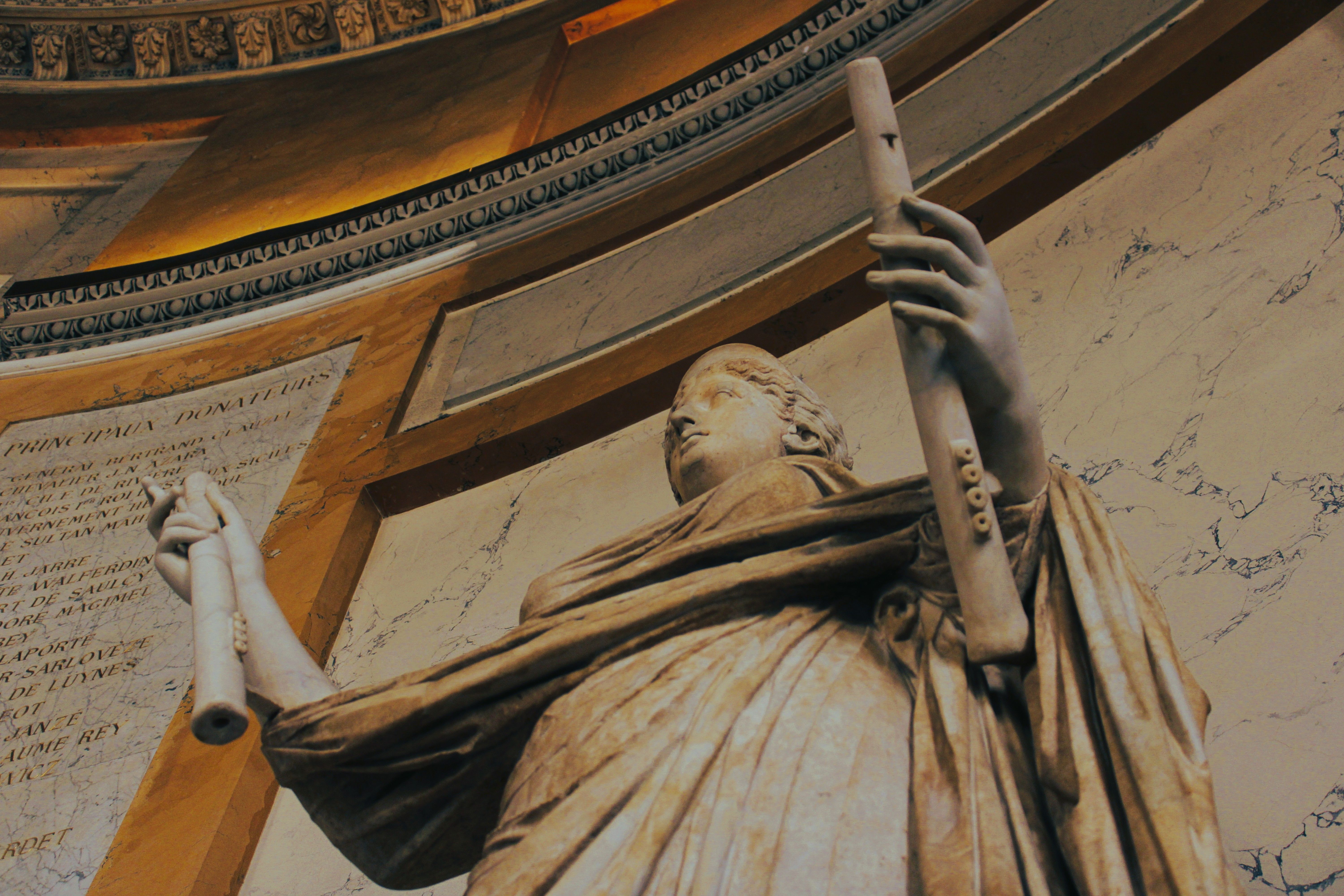 Close-up of a classical statue in a historic Paris monument, showcasing intricate architectural details.