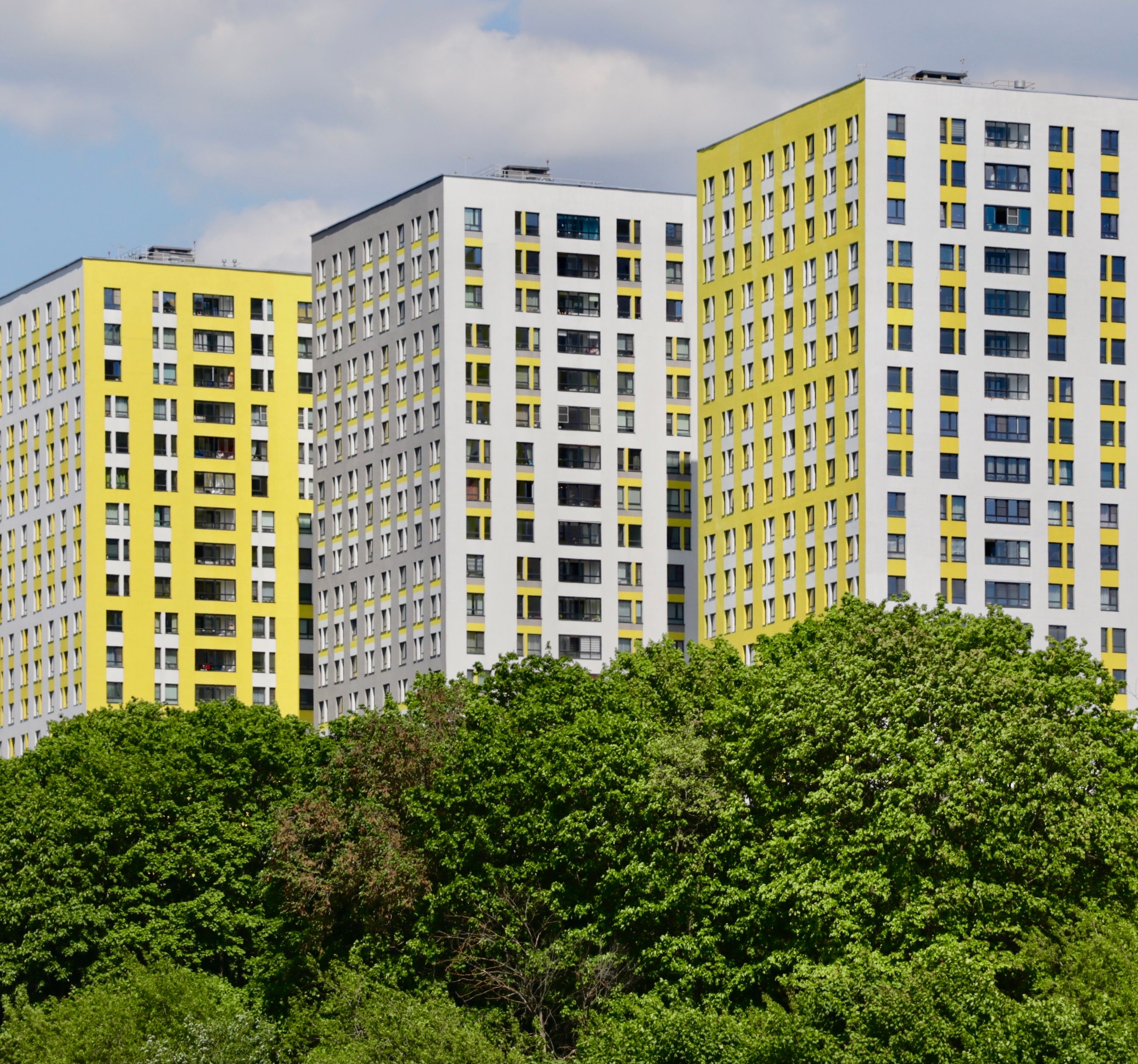 Modern Yellow Apartment Buildings Against Greenery · Free Stock Photo