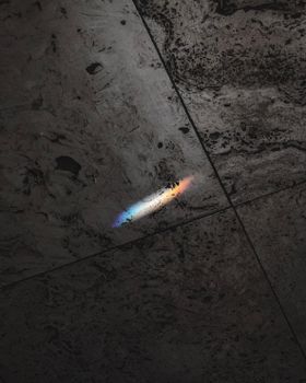 深色纹理瓷砖表面反射出彩虹般的光线