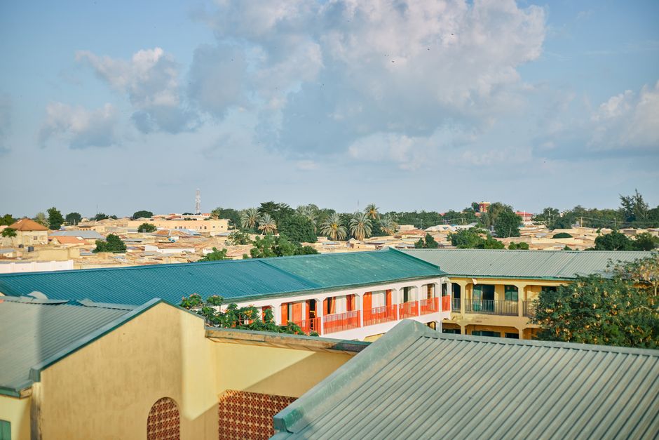 An aerial shot depicting vibrant rooftops and lush greenery under a bright sky.