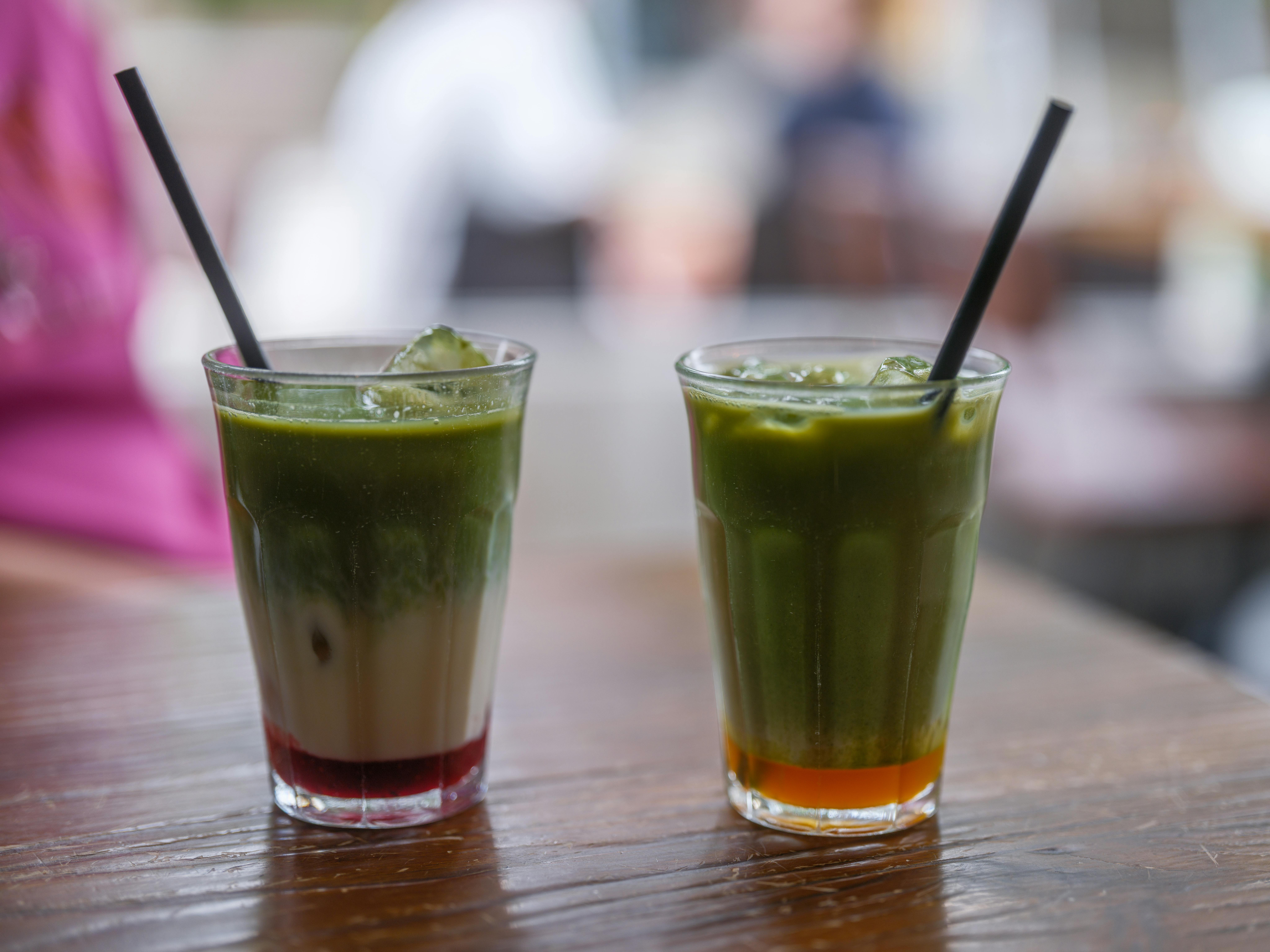 Two iced matcha lattes served in decorative glasses with straws, perfect for a summer day.