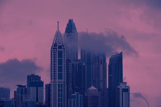 迷人的城市景观中，摩天大楼与云彩在生动的粉红色和紫色日落映衬下格外美丽