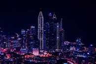 夜幕下，高耸的摩天大楼在绚烂灯光中展现出令人惊叹的城市景观