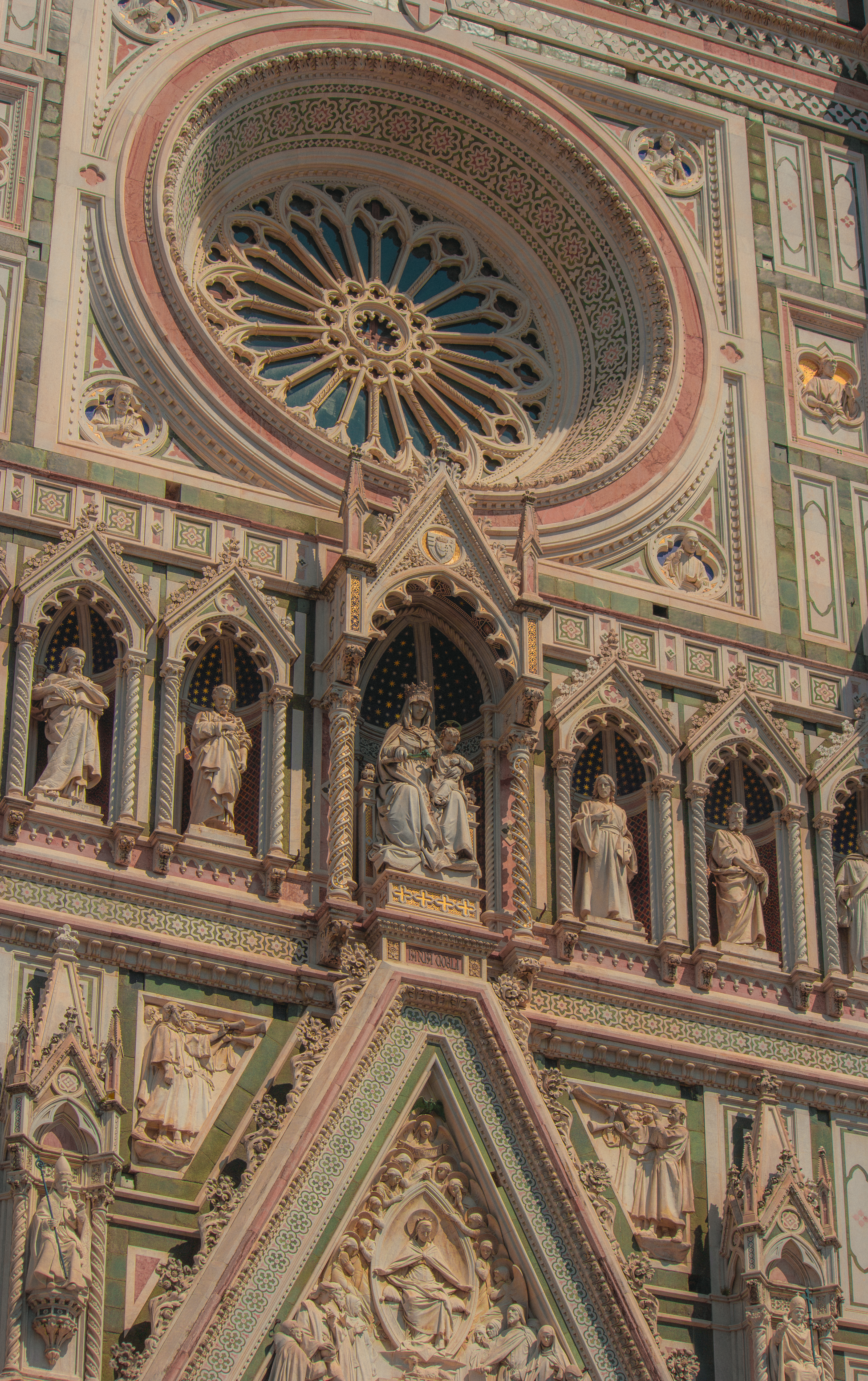 Close-up of Florence Cathedral's intricate Gothic facade under daylight in Italy.