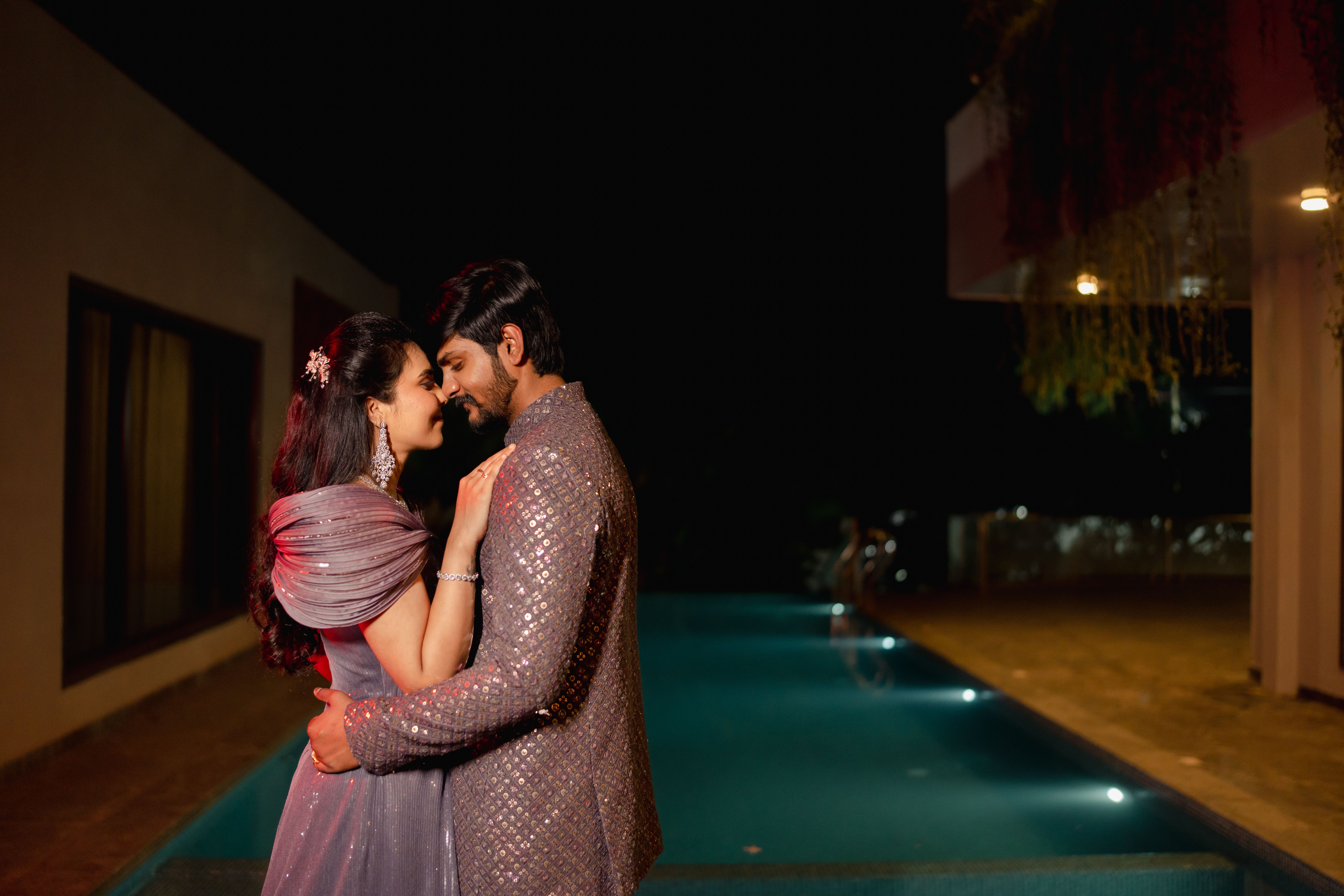 Romantic couple by pool at night
