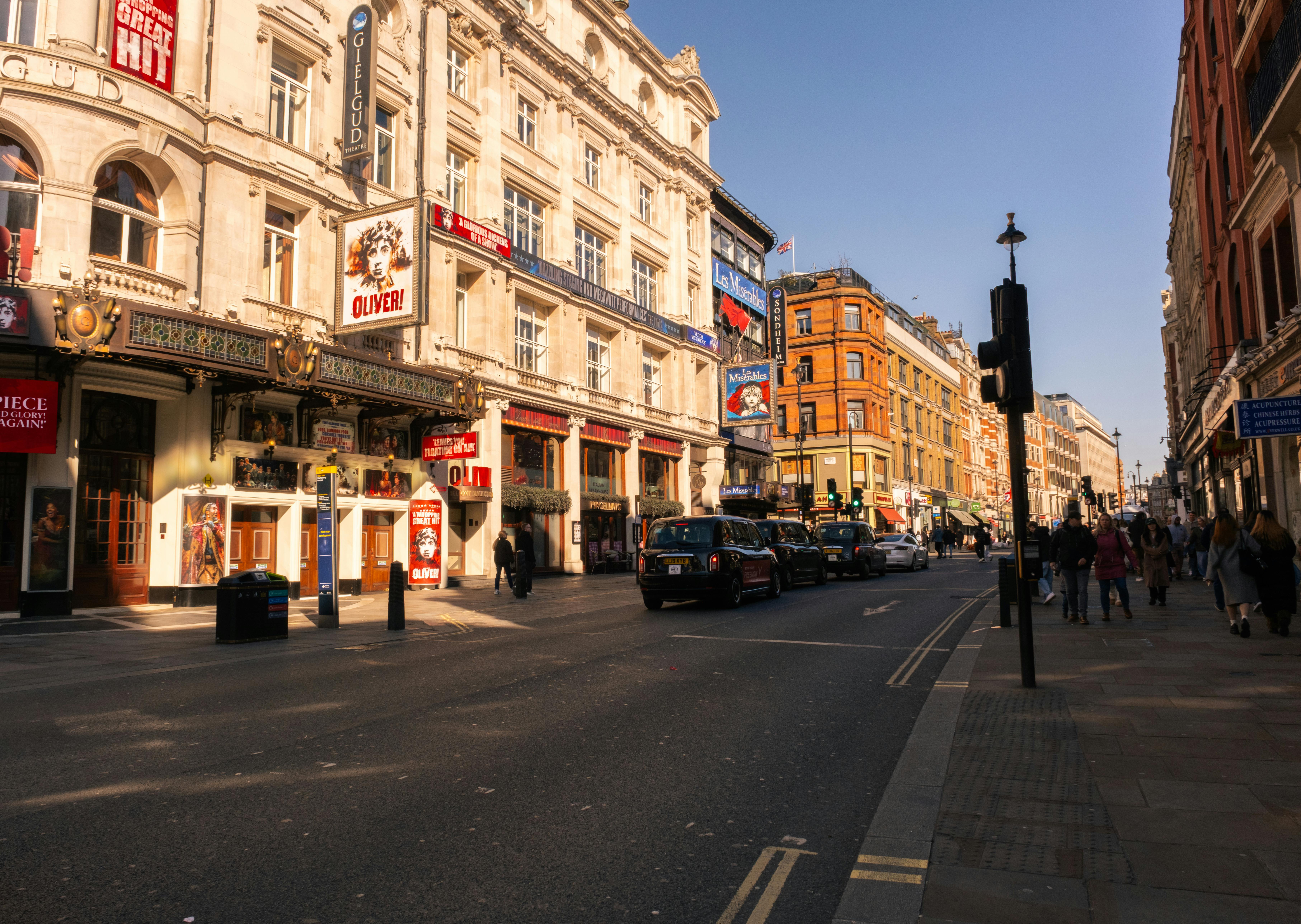 Free Capture of London's bustling West End theatre district bathed in warm daylight showcasing iconic landmarks. Stock Photo
