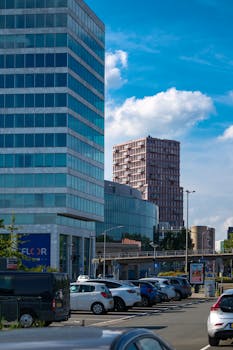 Contemporary buildings and parked cars in Almere, Netherlands, under a clear blue sky.