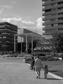 Black and white photo of a family walking in Almere, showcasing modern architecture and urban life.