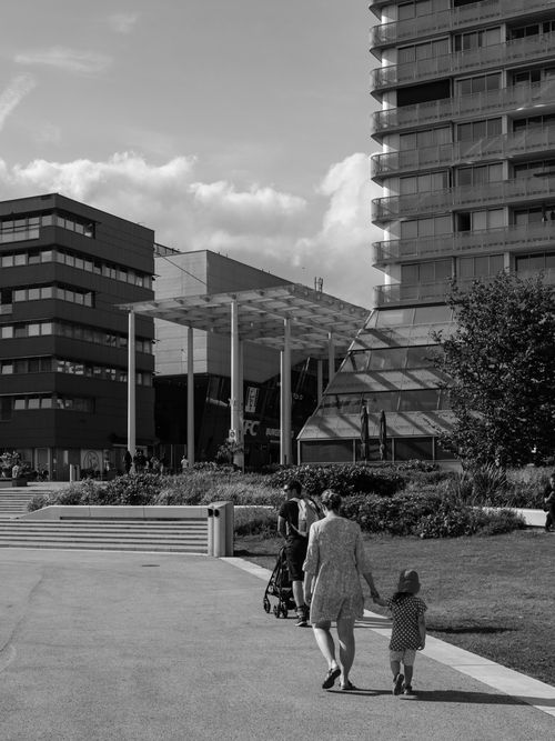 Free Black and white photo of a family walking in Almere, showcasing modern architecture and urban life. Stock Photo