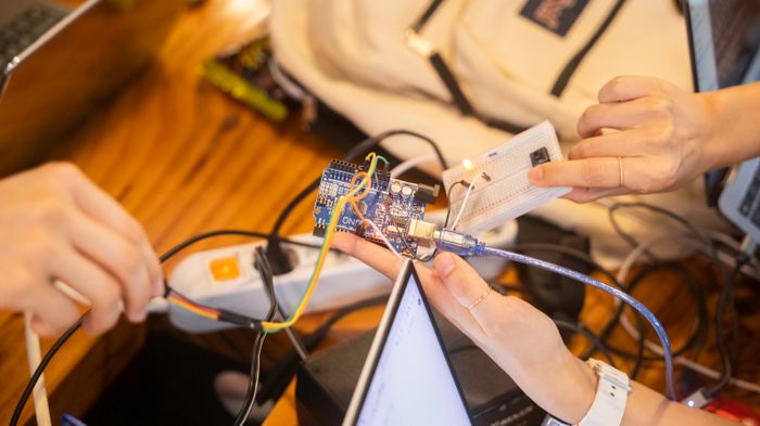 Students wiring a microcontroller project on a breadboard