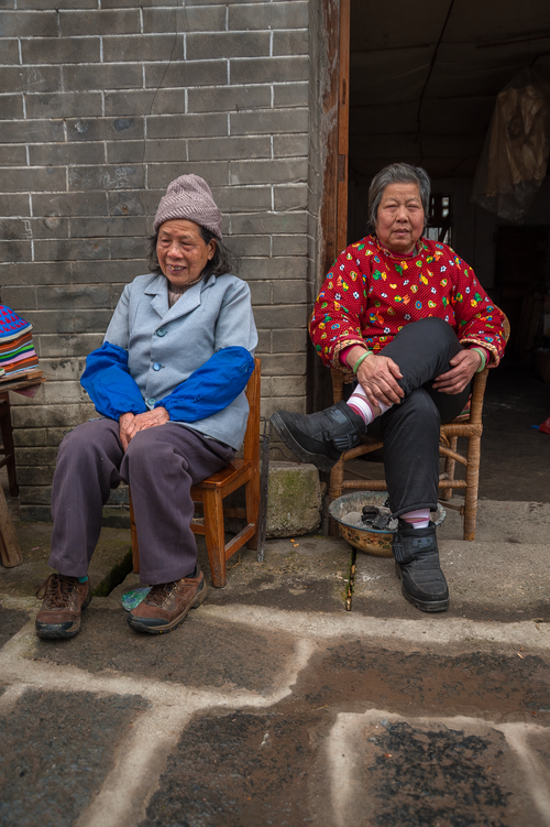 Free Two elderly women sit outdoors in Guilin, Guangxi, China, enjoying a peaceful moment. Stock Photo
