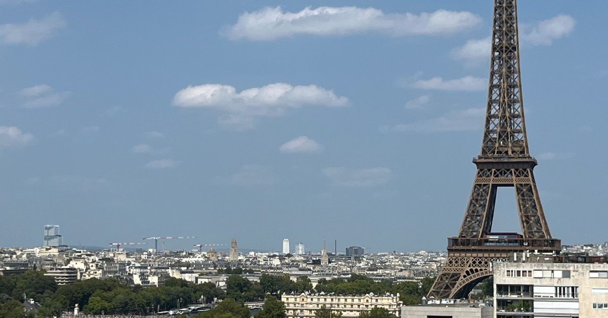The Eiffel Tower rising above the Paris skyline under a clear blue sky