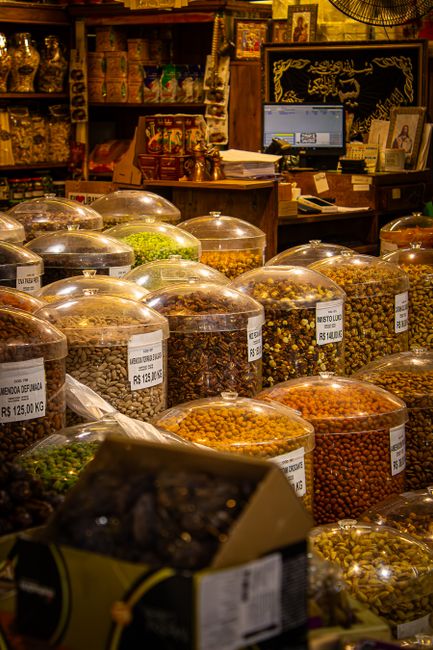 Assorted spices and nuts in jars at a bustling indoor market. - Price Ranges and Value Considerations for Gifting