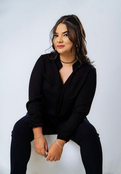 Portrait of a confident woman in a black outfit, showcasing elegance and poise.