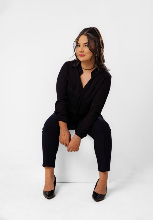 Free Confident woman posing in a modern black outfit against a white background. Stock Photo