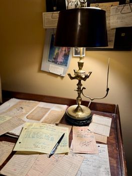 A vintage desk scene with an antique brass lamp and scattered papers, evoking nostalgia.