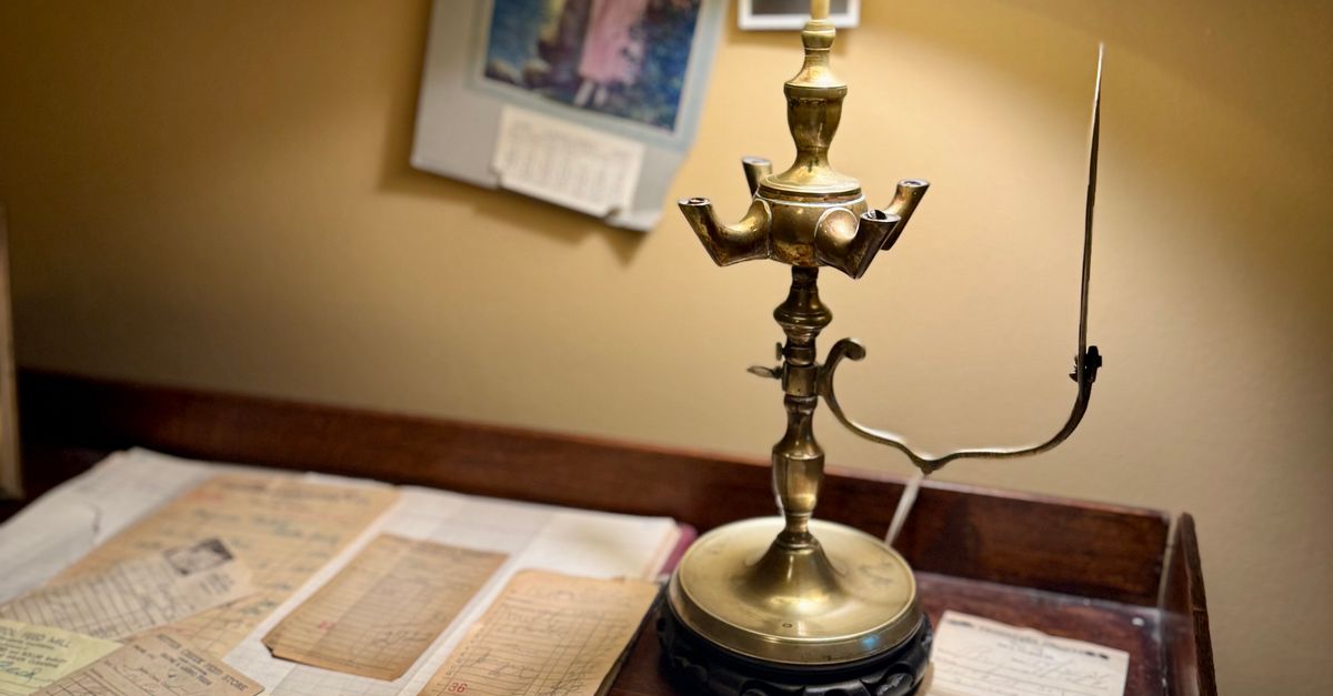 Vintage writing desk with a brass lamp, scattered papers, and a fountain pen in warm light, representing the local, welcoming character of a Fredericksburg law office.