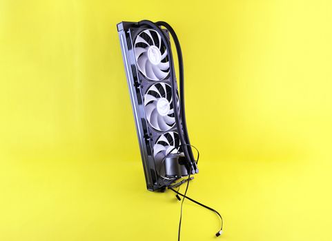 Triple fan PC cooling system with cables against a bright yellow backdrop.
