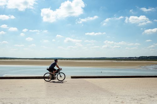 Free A cyclist enjoys a sunny day along the scenic French coast, perfect for outdoor adventures. Stock Photo