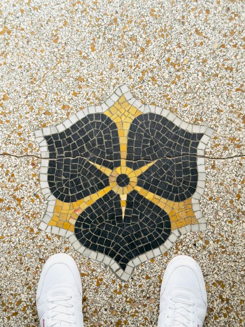 Free Artistic mosaic tile pattern with white sneakers in frame captured in Hamburg. Stock Photo