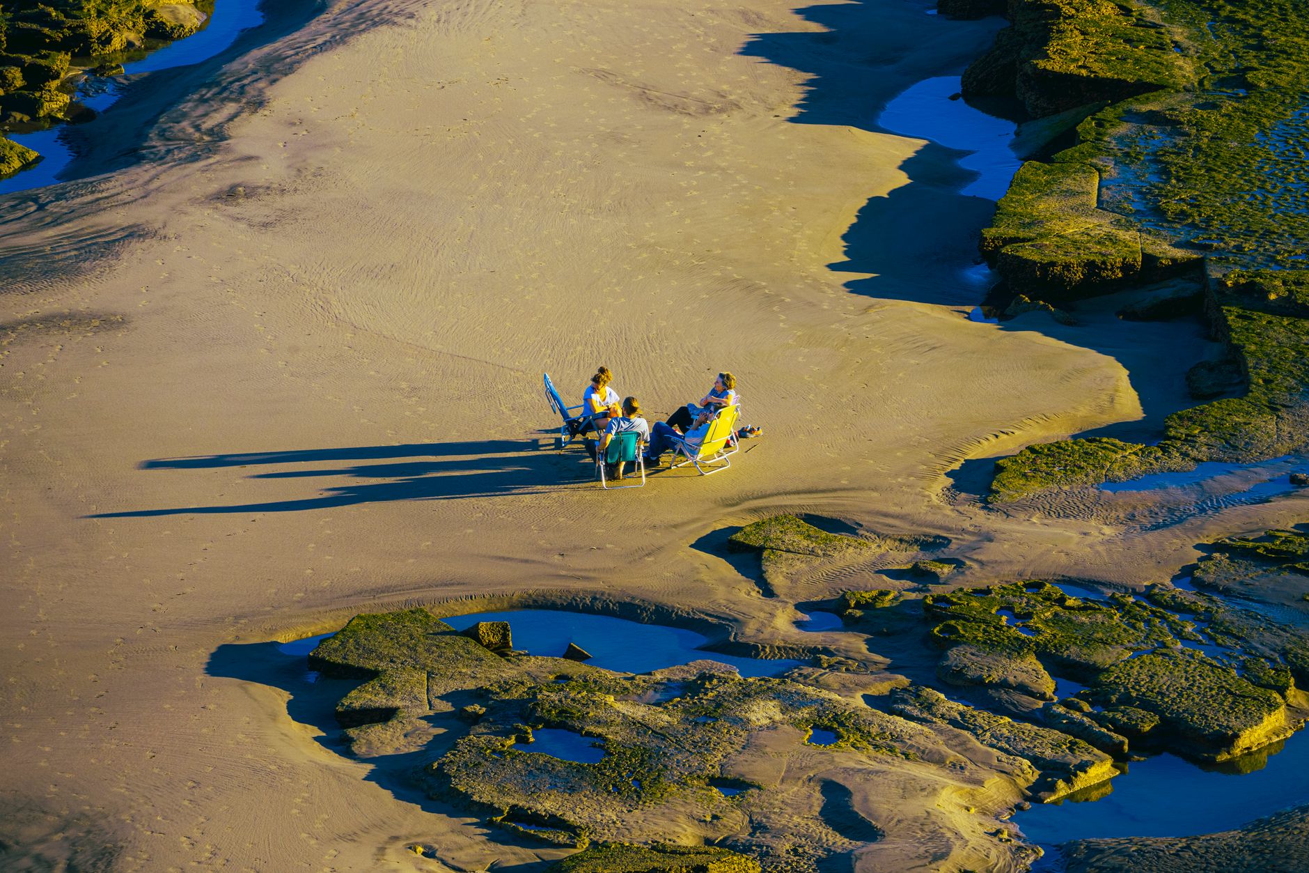 People enjoying a sunny day on the beach at Bahía Creek, Río Negro, Argentina.