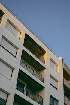 Contemporary apartment exterior with balconies and sunset lighting.