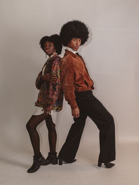Fotomural Dos adultos a la moda posan con ropa vintage sobre un fondo neutro.